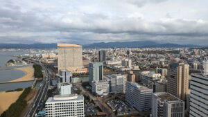 Aerial view of Fukuoka city with skyscrapers and the coastline.