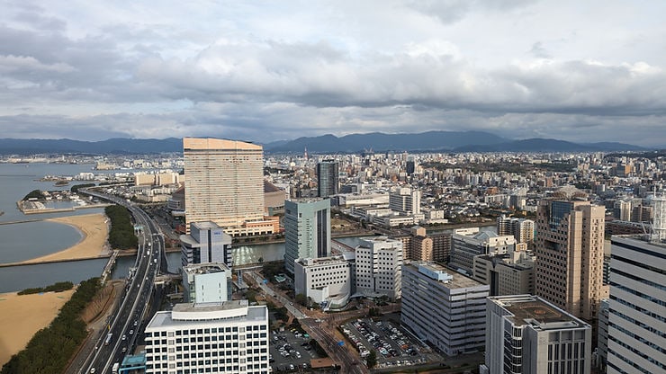 Aerial view of Fukuoka city with skyscrapers and the coastline.