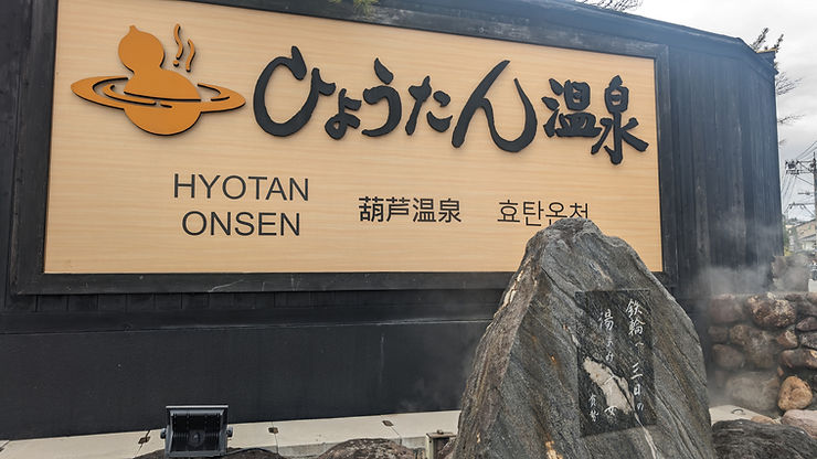 Sign for Hyotan Onsen hot spring in Beppu Japan with Japanese, Korean, and English text.