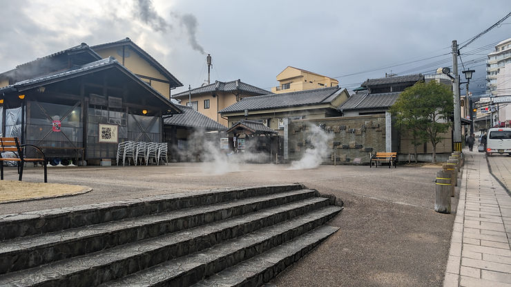 Steam rising from outdoor hot springs in Beppu, Japan.