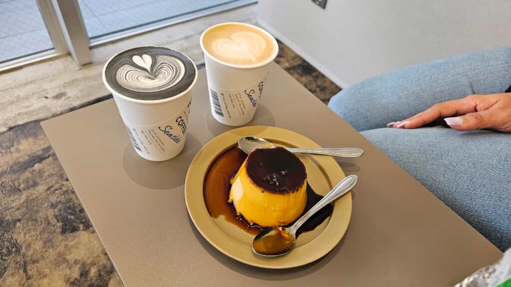 Coffee cups with latte art and caramel flan dessert on a table in Fukuoka.