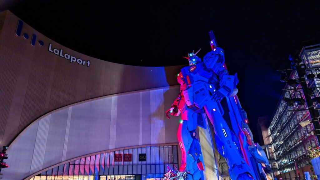 Gundam robot statue illuminated at night in Fukuoka shopping mall.