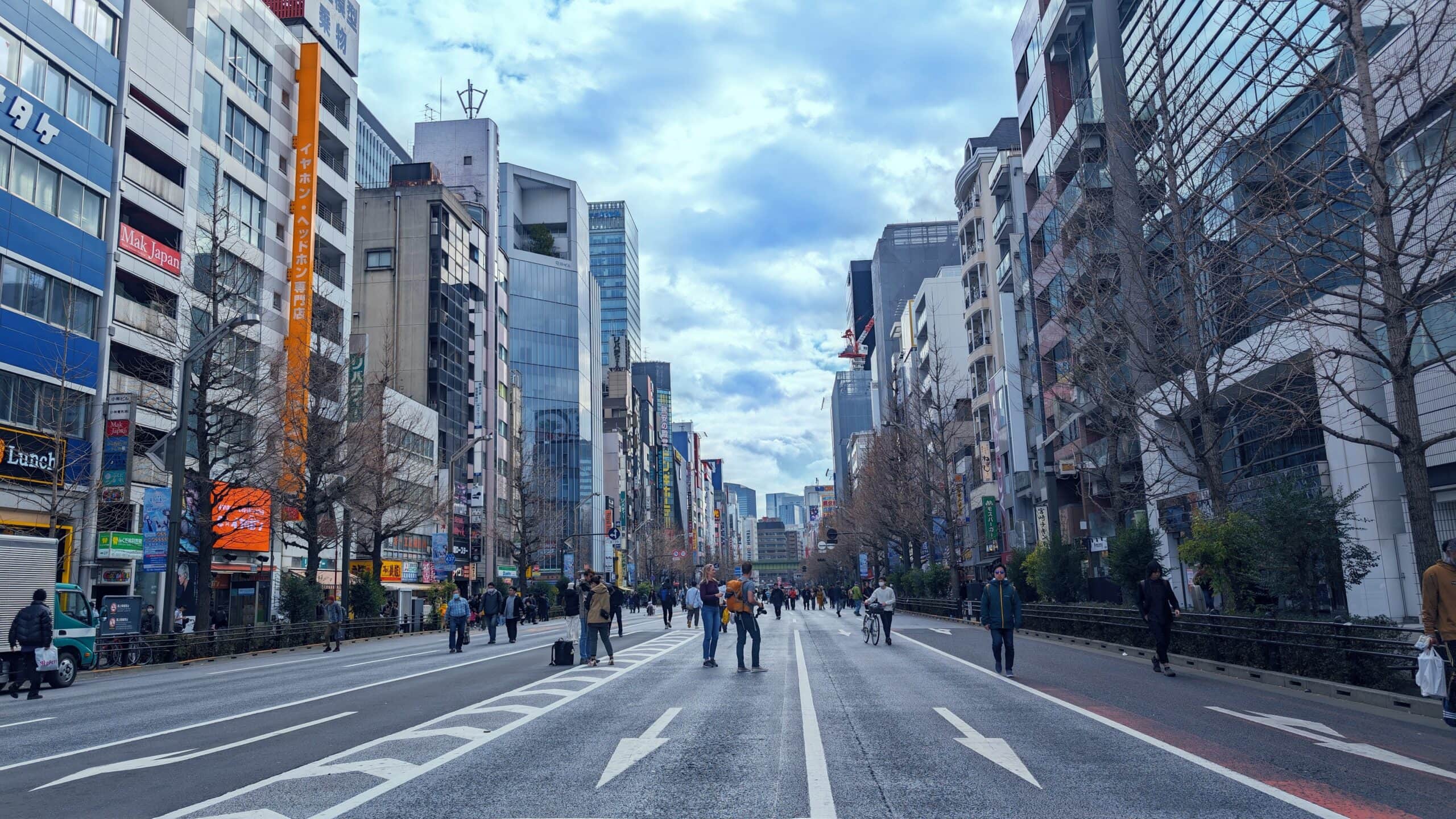 Bustling Tokyo street with skyscrapers and pedestrians.