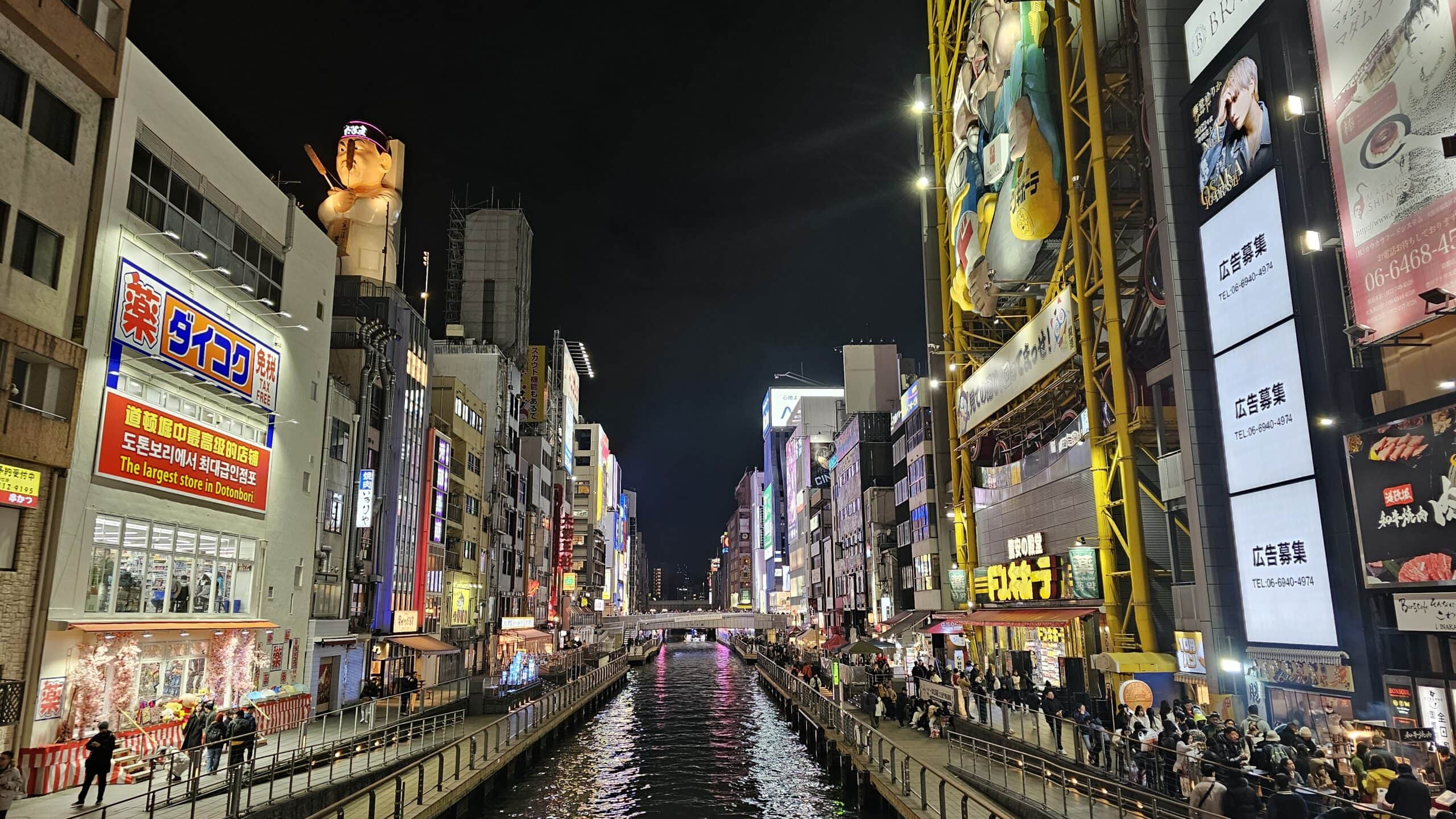 Osaka Dotonbori canal at night with glowing neon signs and a tour boat in the Kansai region of Japan