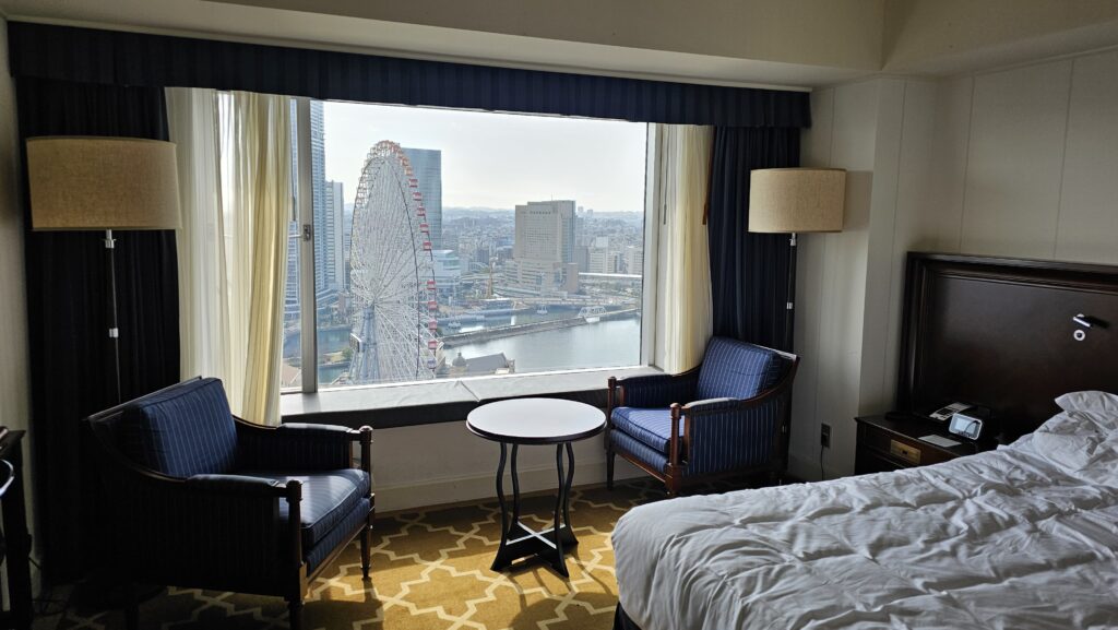 A spectacular panoramic city and harbor view of Yokohama, Japan, captured through the large window of a luxury room at the InterContinental Yokohama.