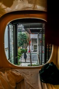 A view from a capsule hotel window revealing a modern city street outside.